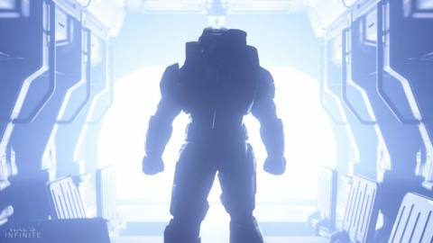 an image of Master Chief from behind, standing at the opening of a spaceship bay with blue light flooding in, in Halo Infinite