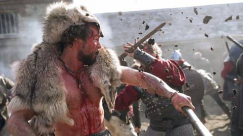 Harald, covered in blood, fends off an attack during a chaotic battle in Vikings: Valhalla