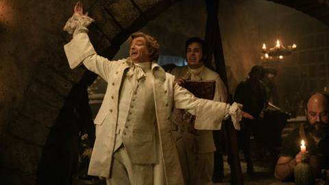 Rhys Darby, fopping it up real hard in a fancy white 18th-century topcoat, with Nathan Foad lurking uncomfortably in the background, in Our Flag Means Death