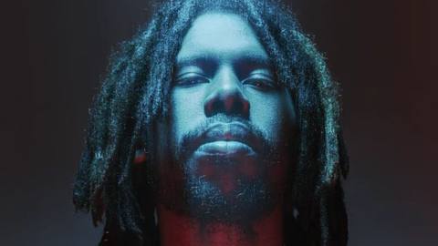 Flying Lotus bathed in blue and red light.