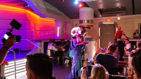 A purple Twi’lek croons over a hasty meal aboard the Halcyon.