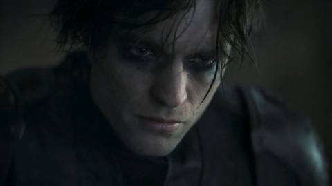 Robert Pattinson as Bruce Wayne in The Batman. He wears his Batman costume but without the mask; his eyes ringed with black makeup.