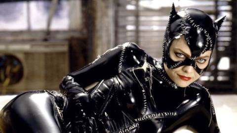 Michelle Pfeiffer, sprawling on a white fur in the Catwoman suit and smiling at the camera in a PR still for Batman Returns