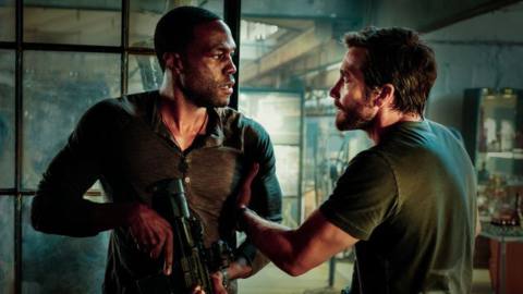 Jake Gyllenhaal and Yahya Abdul-Mateen II face off, holding automatic weapons