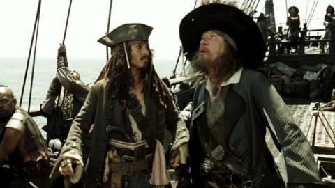 jack sparrow and hector barbossa standing on the deck of a ship