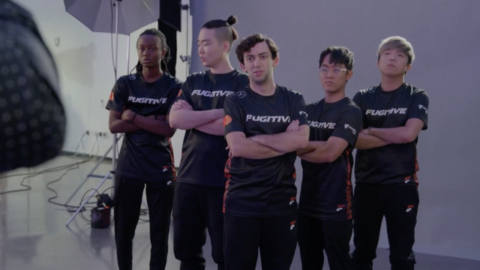 five esports players stand with their arms crossed over their chests