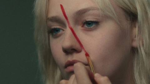 Dakota Fanning paints her faced red in The Runaways.