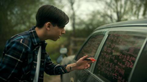 Five writing equations on a car window and looking confused