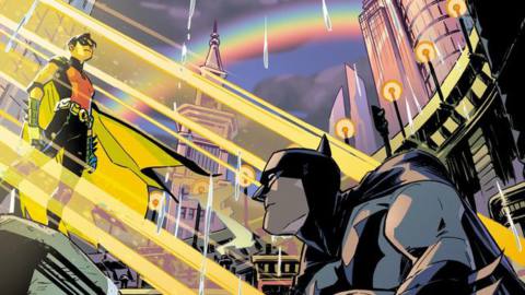 Robin stands in a beam of dawn sunlight, with Batman crouched beneath. Two rainbows arc through Gotham’s sky, on a variant cover for Batman #124 (2022). 