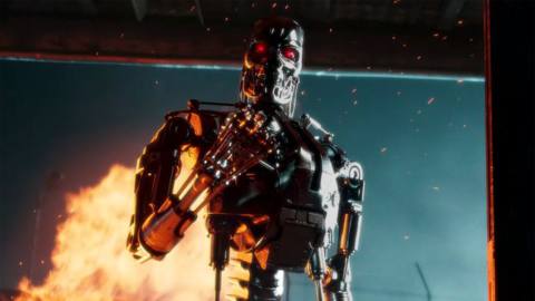 A Terminator T-800 exoskeleton curls its fist while something burns behind it