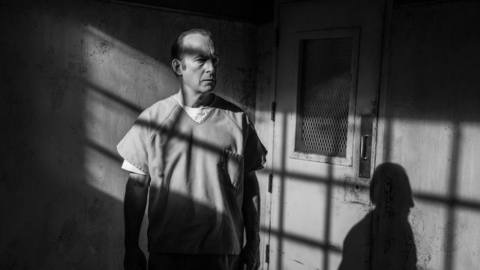 a black-and-white shot of Jimmy McGill in prison; the light from the window makes a windowpane shadow on his face and on the wall next to him