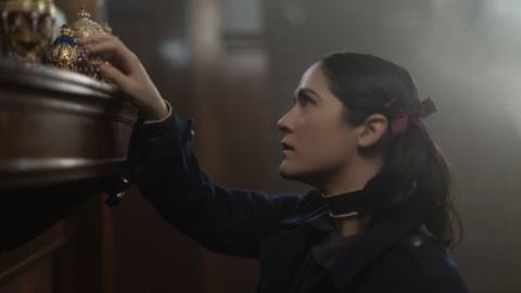 Isabelle Fuhrman as Esther in Orphan: First Kill looking at something on a shelf