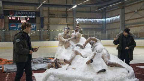 The corpsicle — still, partially frozen bodies all writhing in terror — sits in the middle of an ice rink while two cops walk around it