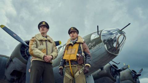 Callum Turner and Austin Butler stand befor Our Baby, one of the many il-fated Fortresses that co-star in Masters of the Air. It’s bristling with guns.