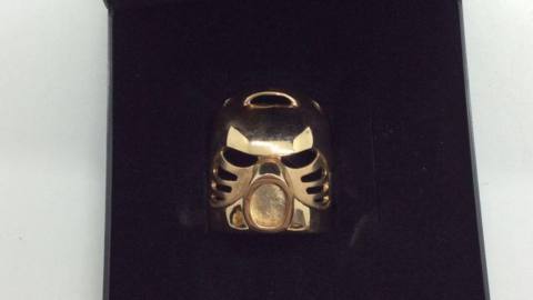 Golden Lego Bioncle mask in a black jewelry box