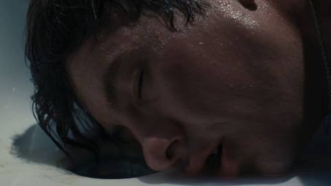 Oliver (Barry Keoghan) presses his lips to a bathtub drain as he laps up the bathwater of his crush Felix in Saltburn