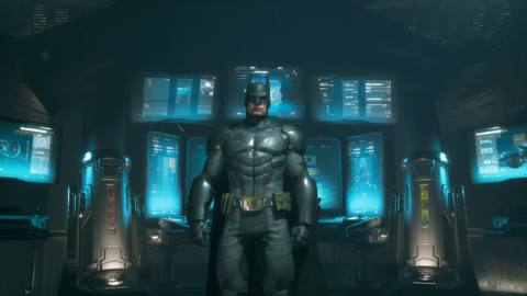 Batman stands in front of a group of computer terminals at a Batcave in a screenshot from Suicide Squad: Kill the Justice League