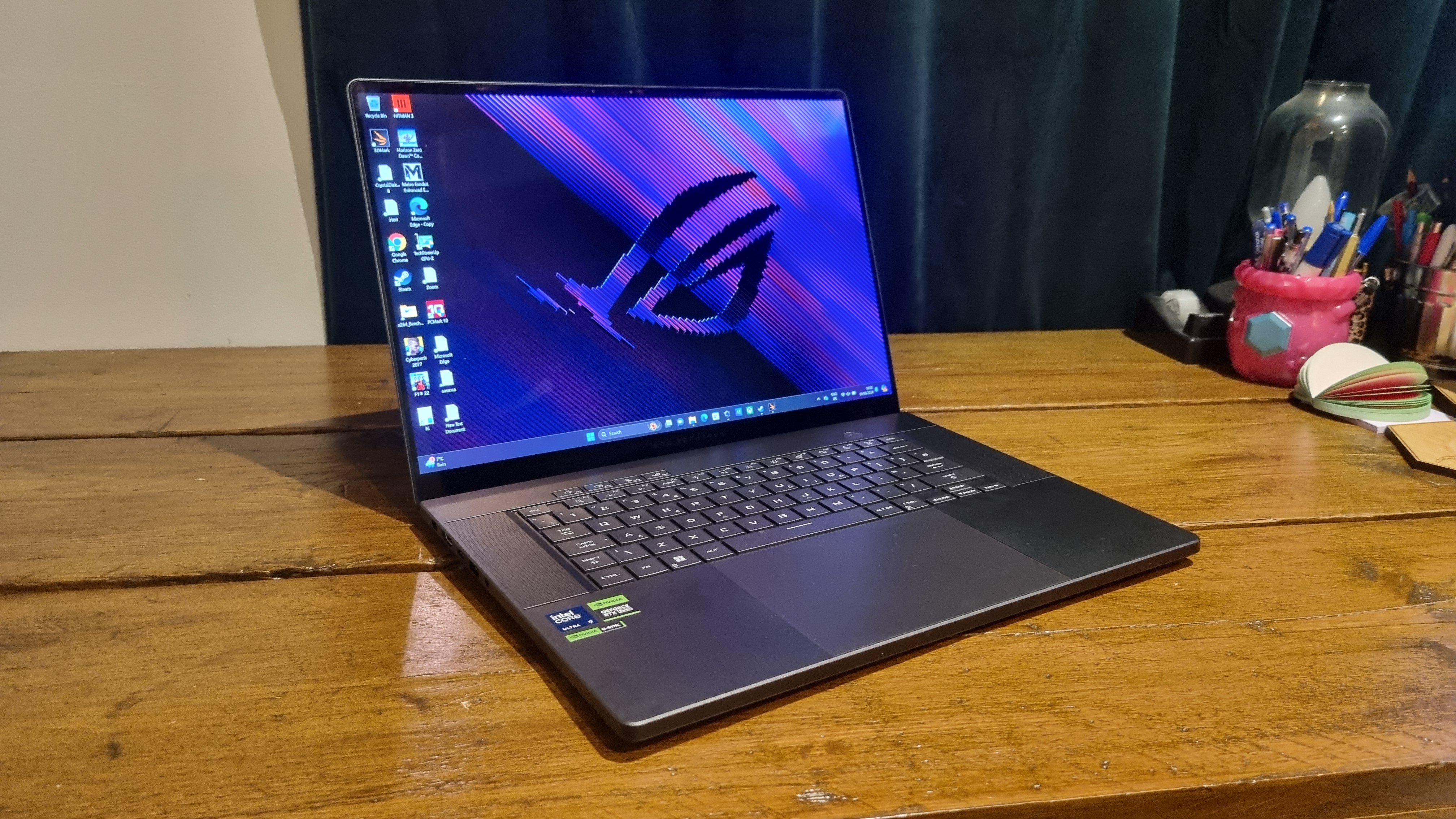 The Asus ROG Zephyrus G16 on a wooden desktop at an angle