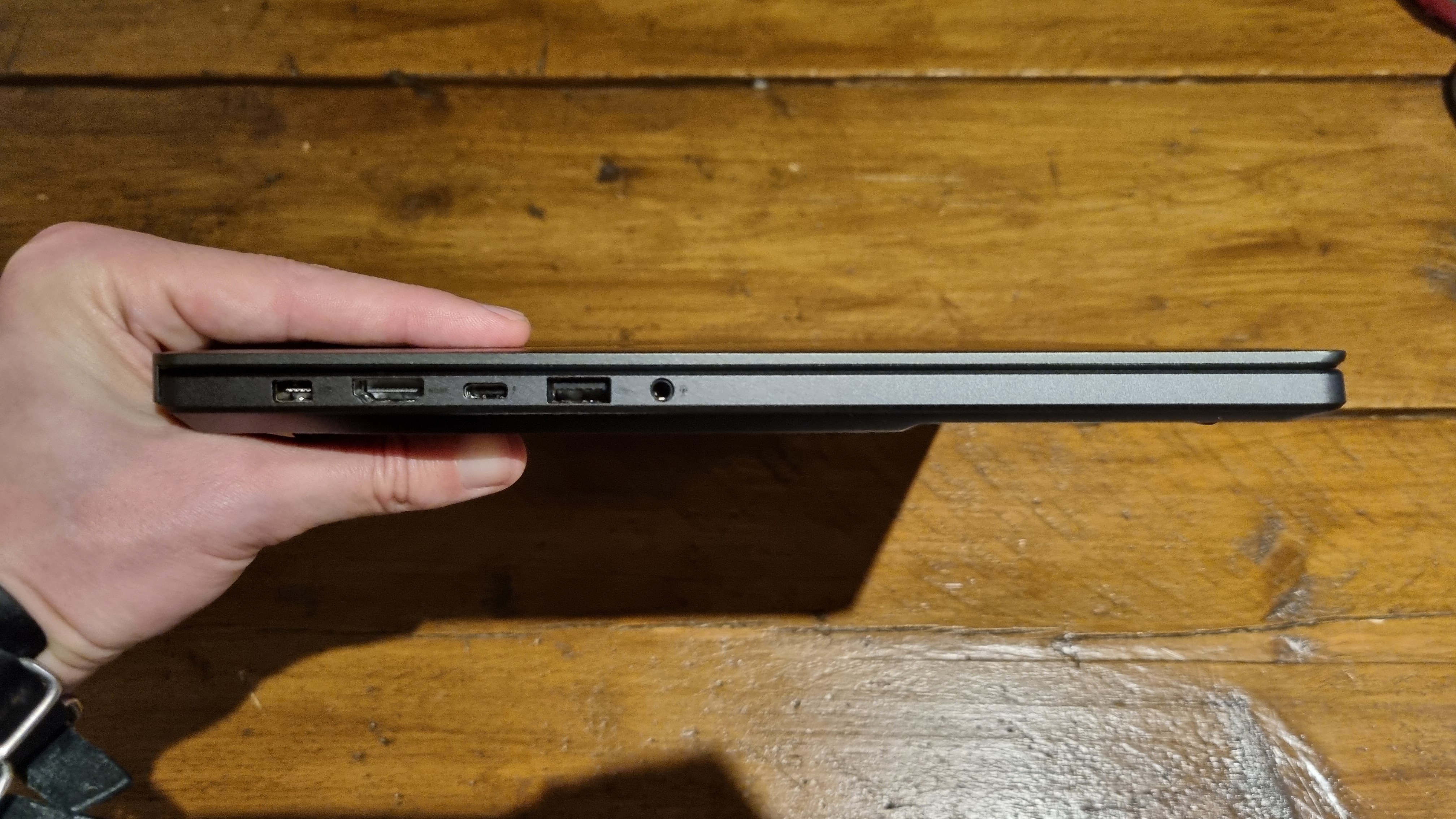 The Asus ROG Zephyrus G16 2024 held to show the thinness of the laptop overall