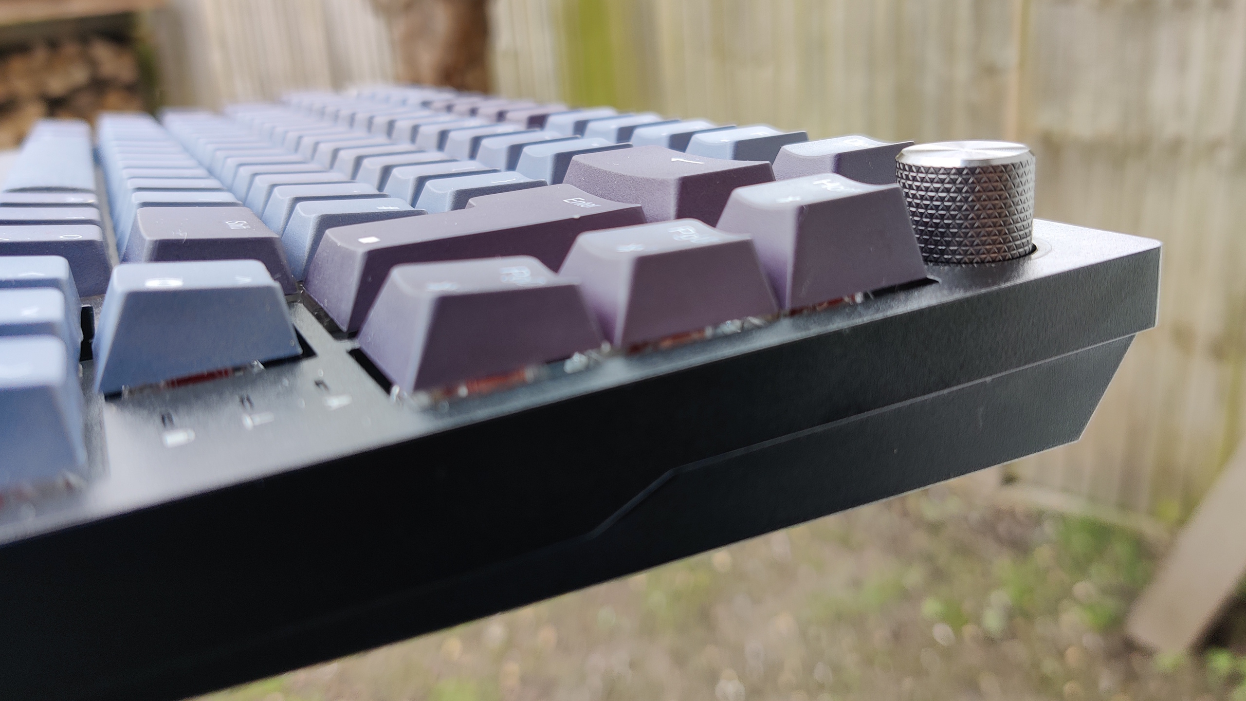 Corsair K65 pictured outdoors with black and grey keycaps.