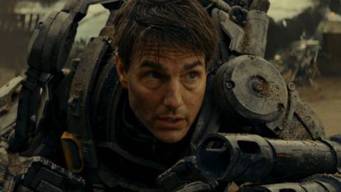 Tom Cruise’s military officer in an exosuit falls to the ground catching his breath during the heat of alien war in Edge of Tomorrow