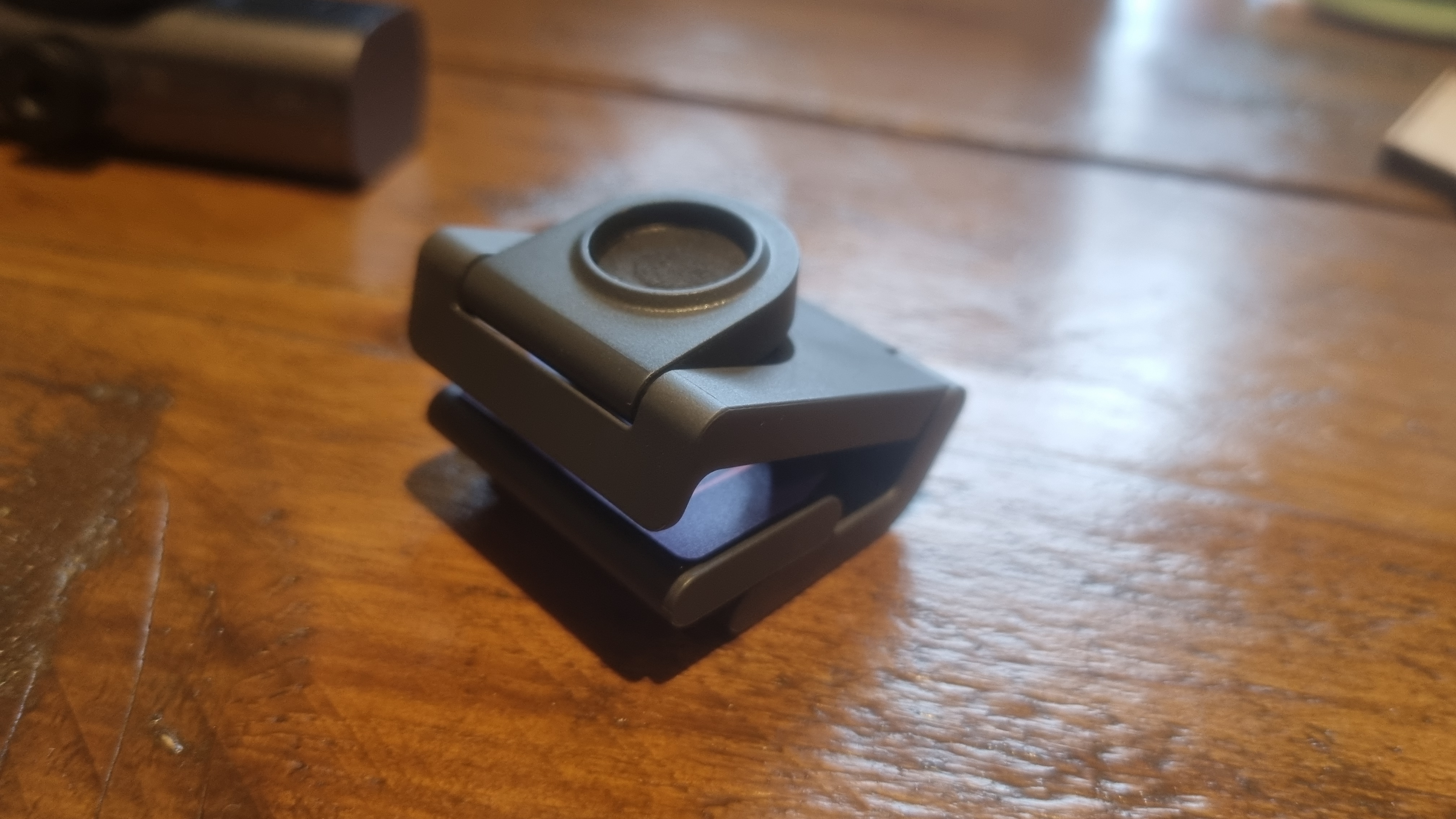 The mount for the Logitech MX Brio on a wooden desk