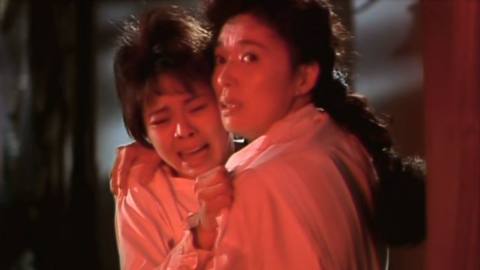 Akiko (Nobuko Miyamoto) holds Emi (Nokko) as they watch Asuka’s melting body in a still from Sweet Home