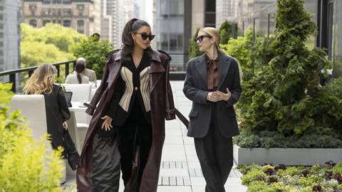 Siobhan (Kim Kardashian) walks with Anna (Emma Roberts) and talks in a still from AHS: Delicate