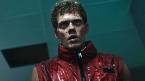 Boy (Bill Skarsgård, in a red, sleeveless leather jacket, and spattered with about a gallon of blood) stares grimly into the camera with his mouth hanging dorkishly open in Boy Kills World