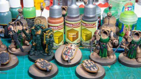 Several miniatures of the Dark Angels Deathwing Company ready for metallics. They’re sitting next to three bottles of The Army Painter paint.