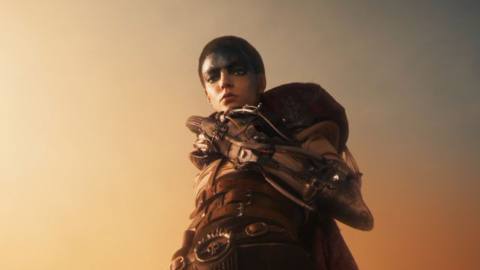 Furiosa (Anya Taylor-Joy) stands above the camera, glowering down into the lens, in George Miller’s Furiosa