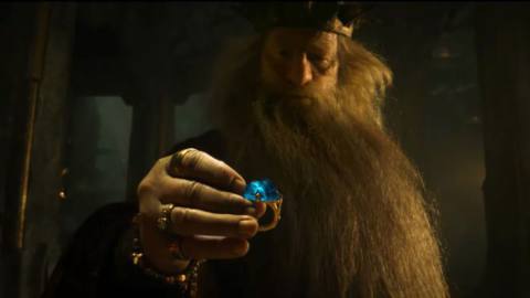 King Durin picks up a golden ring with a huge blue gem set into it in The Lord of the Rings: The Rings of Power.