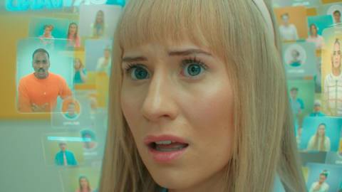 A close up of Lindy, her face visible behind a bunch of transparent screens projected around her face in the Doctor Who episode “Dot and Bubble.”