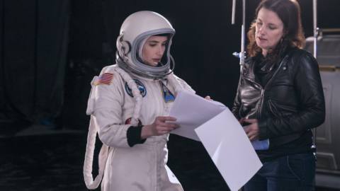 Emma Roberts wearing an astronaut suit going over a script with director Liz W. Garcia