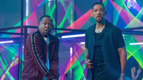 Martin Lawrence and Will Smith stand in a neon-bathed room, making surprised faces, in Bad Boys: Ride or Die