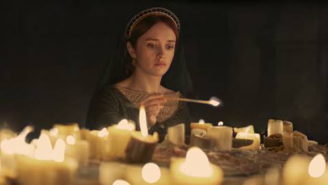 Alicent lights a bevy of candles in a dark room in House of the Dragon season 2