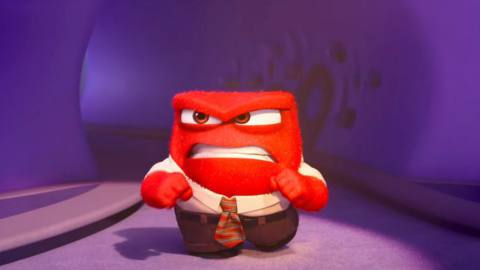 Anger, the short red snarly emotion from the Inside Out movies, walks along a corridor looking appropriately annoyed in Pixar animation Studios’ Inside Out 2