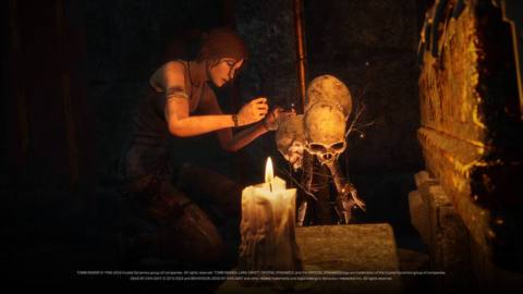 Lara Croft painstakingly disarms a hex totem in Dead by Daylight. She is a brunette woman in a blue tank top, her hair tied back into a ponytail, crouching over a totem comprised of human skulls.