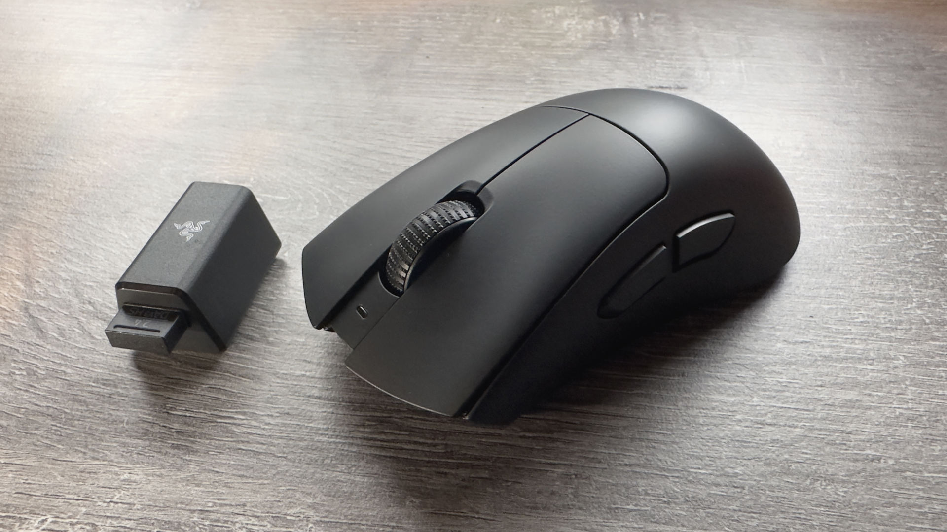 A photo of a Razer DeathAdder V3 HyperSpeed gaming mouse resting on an office desk