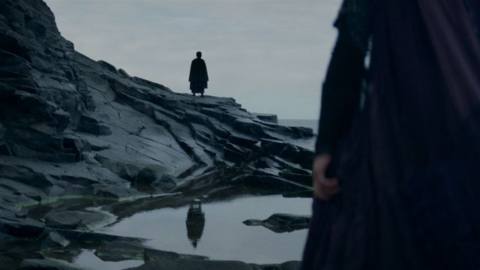 A shadowy Sith figure stands on rocks in a still from The Acolyte