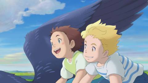 Amanda, a young brown-haired girl, and her imaginary friend Rudger, a similarly aged blond boy, both grin as they fly through the sky on a giant bird in a scene from Studio Ponoc’s anime movie The Imaginary 