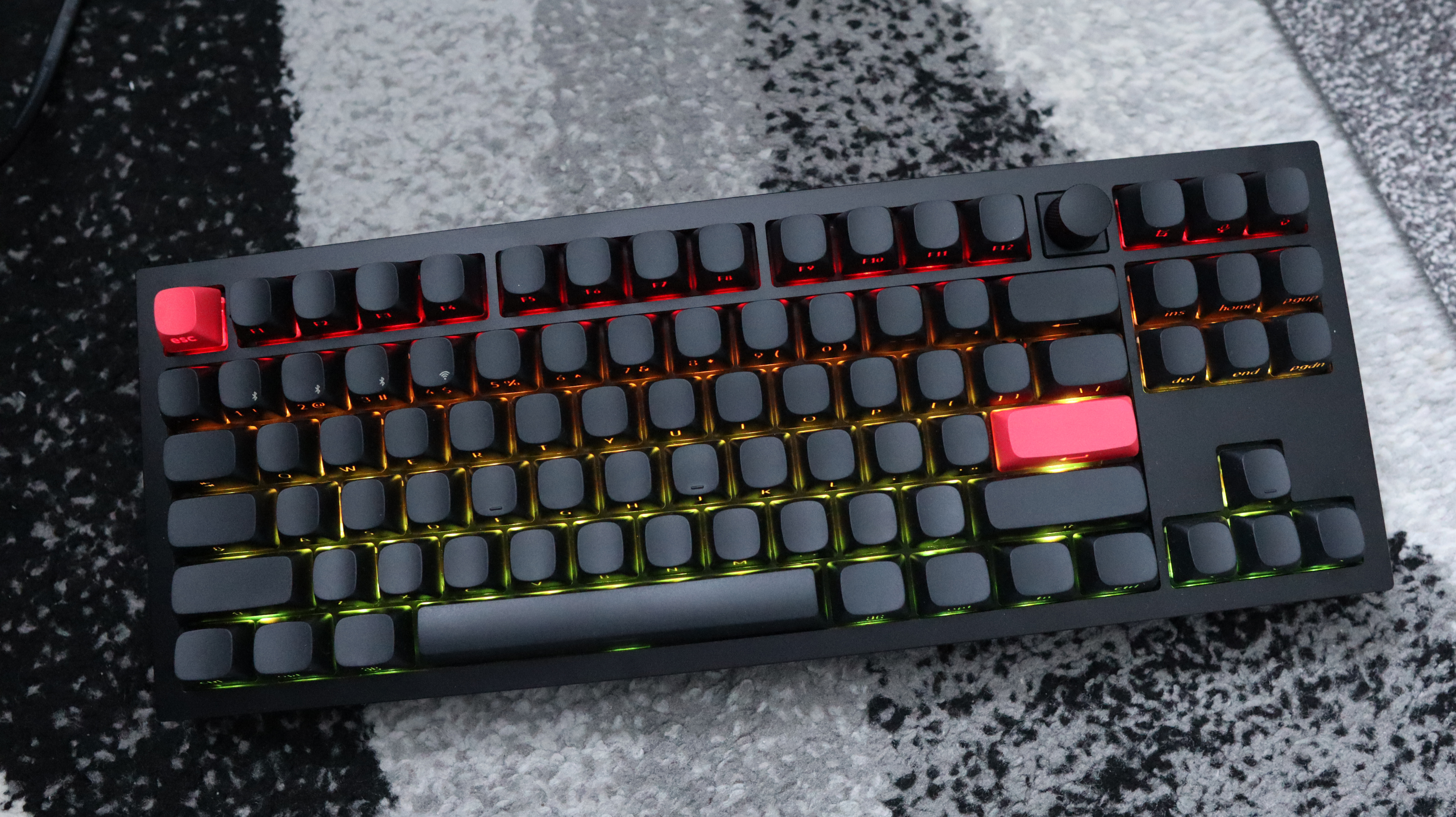 The Keychron Q3 Max gaming keyboard set-up on a desk with the RGB lighting enabled.
