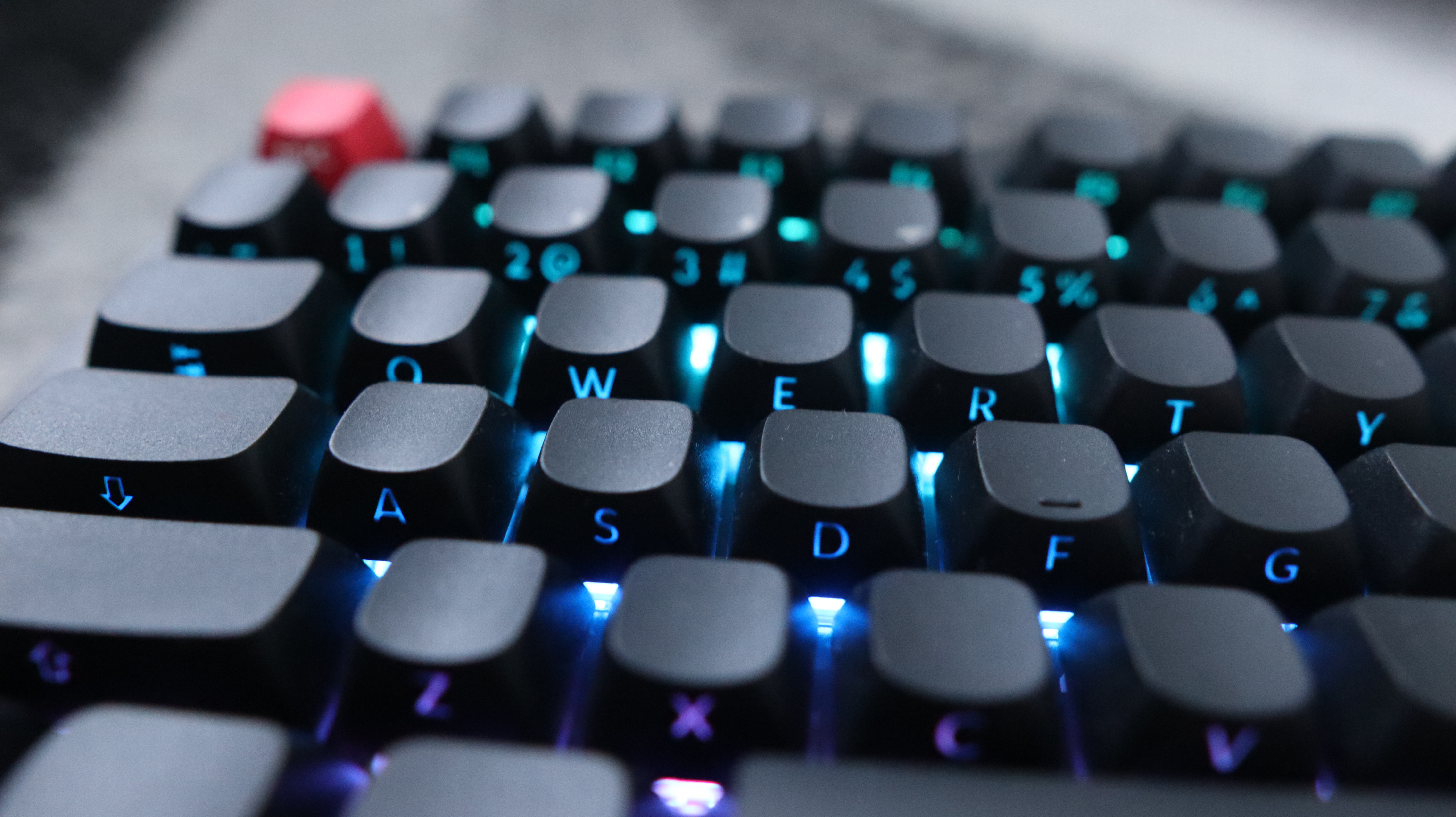 The Keychron Q3 Max gaming keyboard set-up on a desk with the RGB lighting enabled.