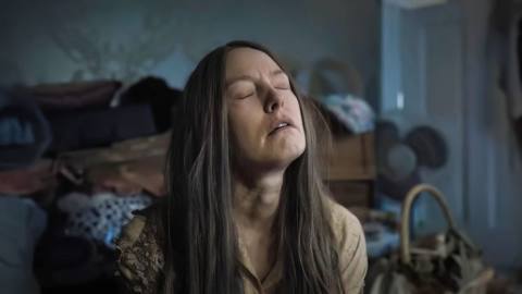 Ruth (Alicia Witt), a long-haired woman with a strained, weary face, grimaces in seeming exhaustion in Oz Perkins’ horror movie Longlegs