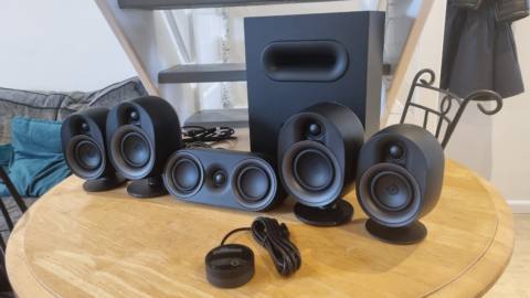 The SteelSeries Arena 9 illuminated 5.1 desktop speakers, arranged in a row on a wooden table