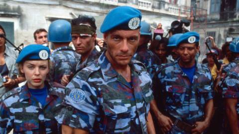 Jean-Claude Van Damme, Kylie Minogue, and other Allied Nations soldiers face the camera wearing red white and blue army camo fatigues in Street Fighter th emovie.