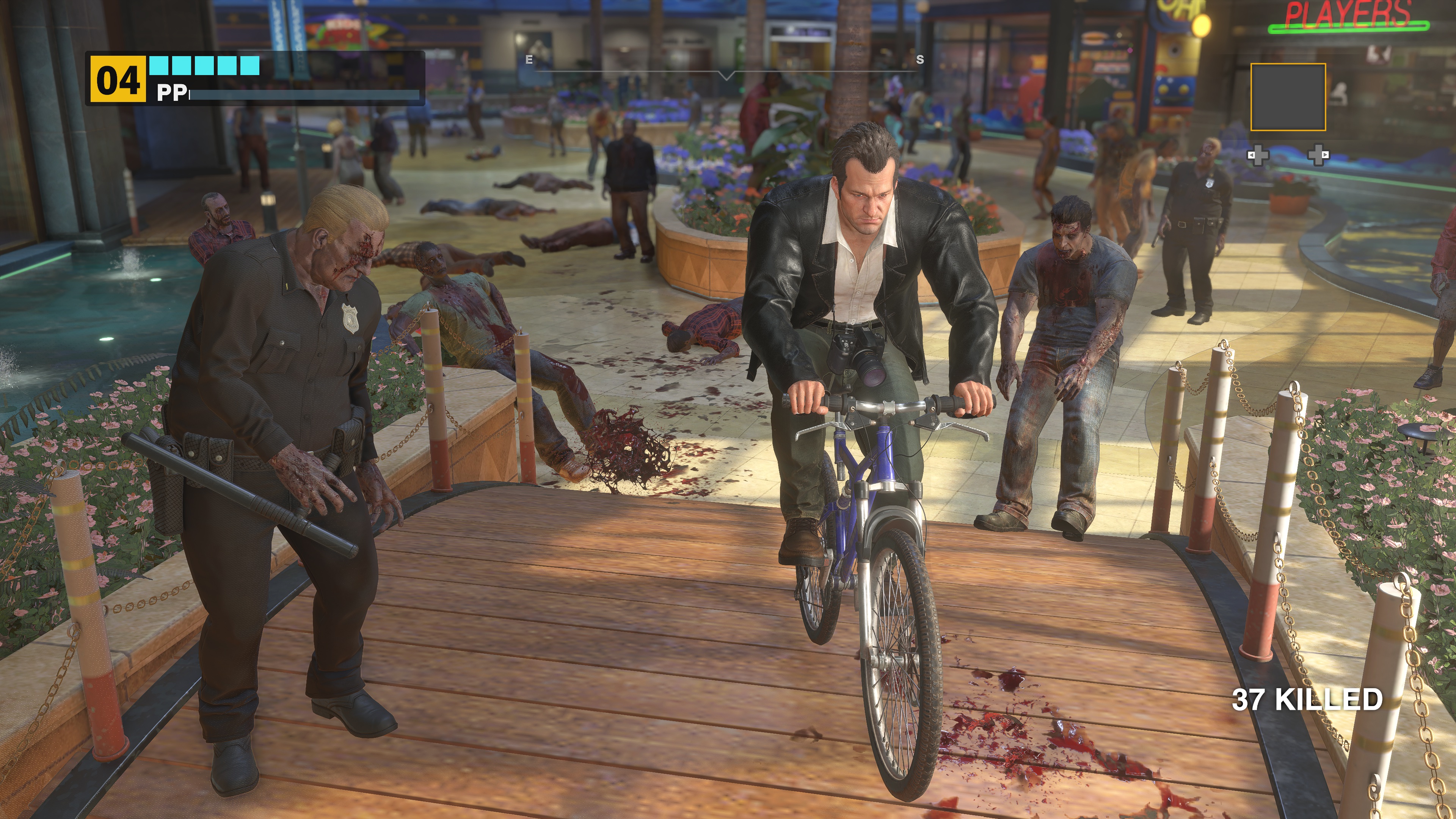 Frank West rides a bicycle over a wood bridge past a zombie cop in a screenshot from Dead Rising Deluxe Remaster