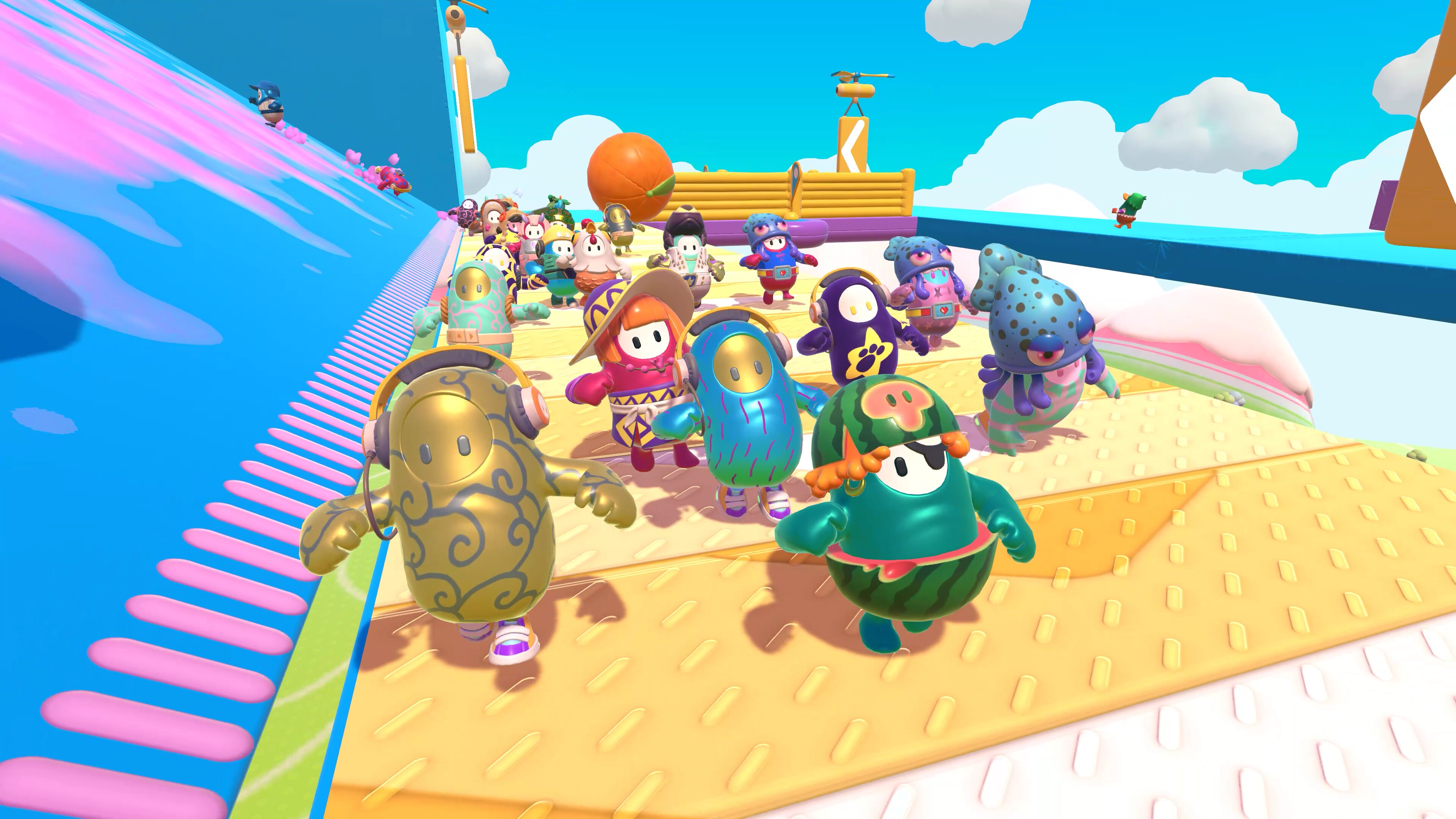 An image of a bunch of bean characters in the original Fall Guys running through an obstacle course.