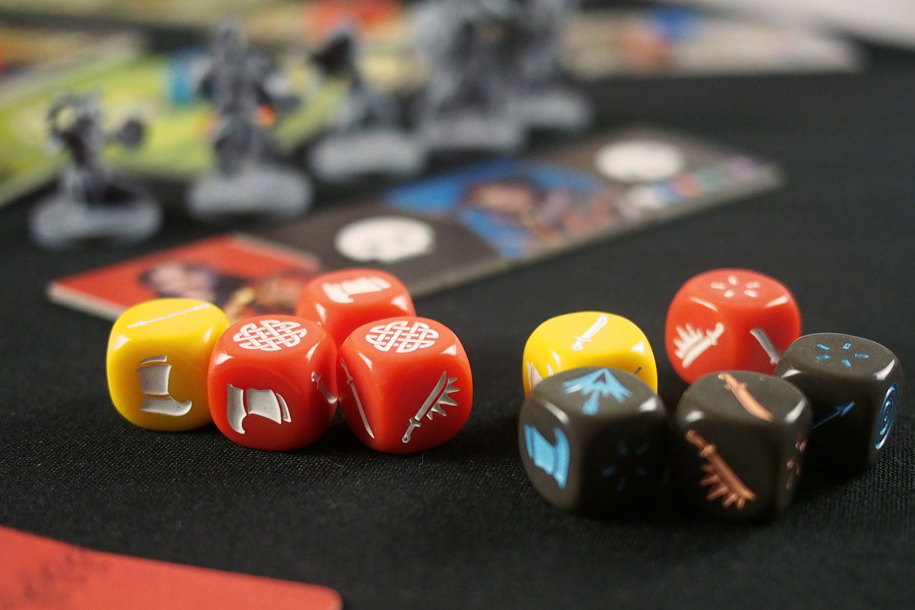 Custom dice include yellow, red, and black plastic items with swords, feet, and sigils on their faces.