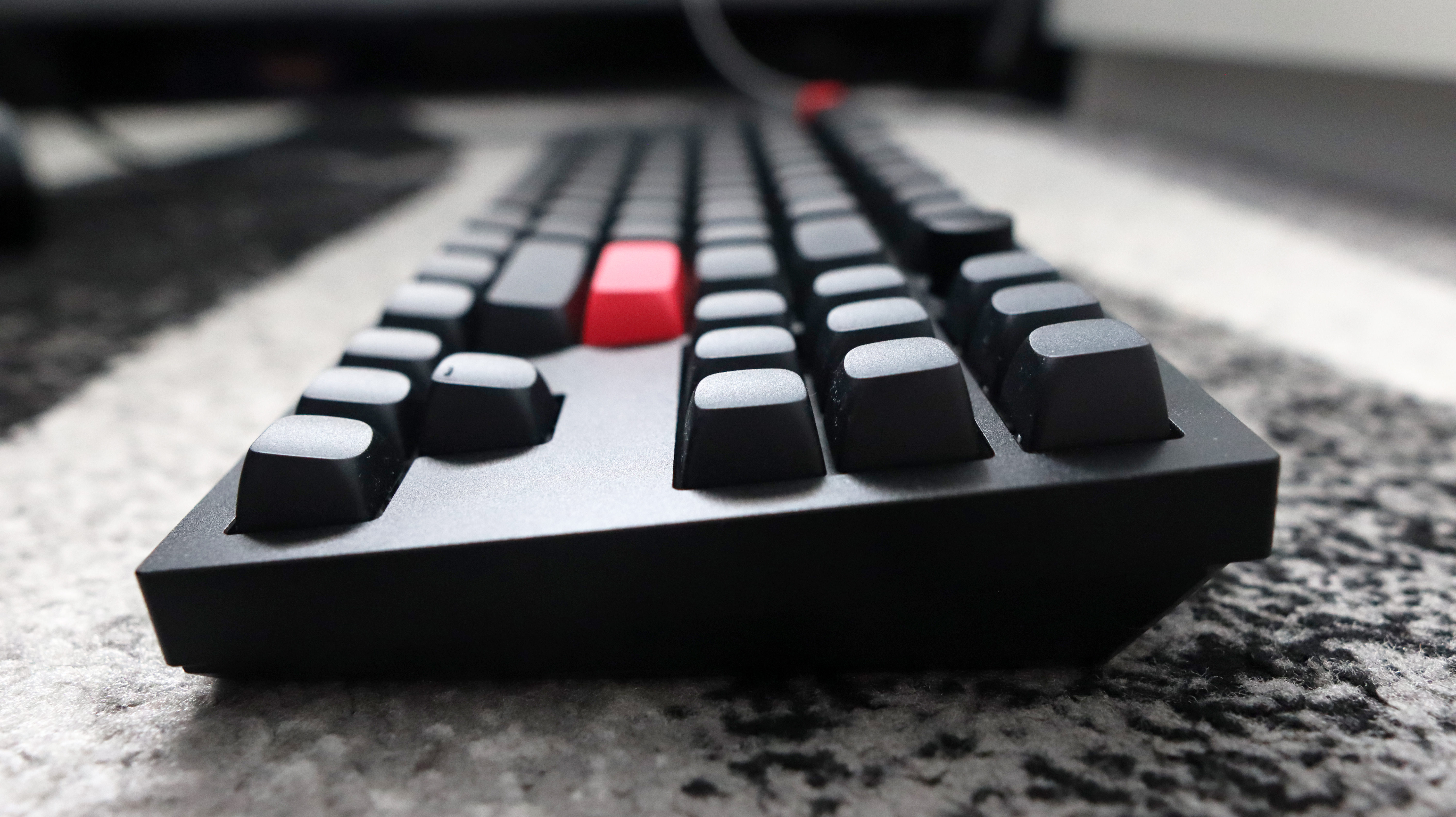 The Keychron Q3 Max gaming keyboard set-up on a desk with the RGB lighting enabled.